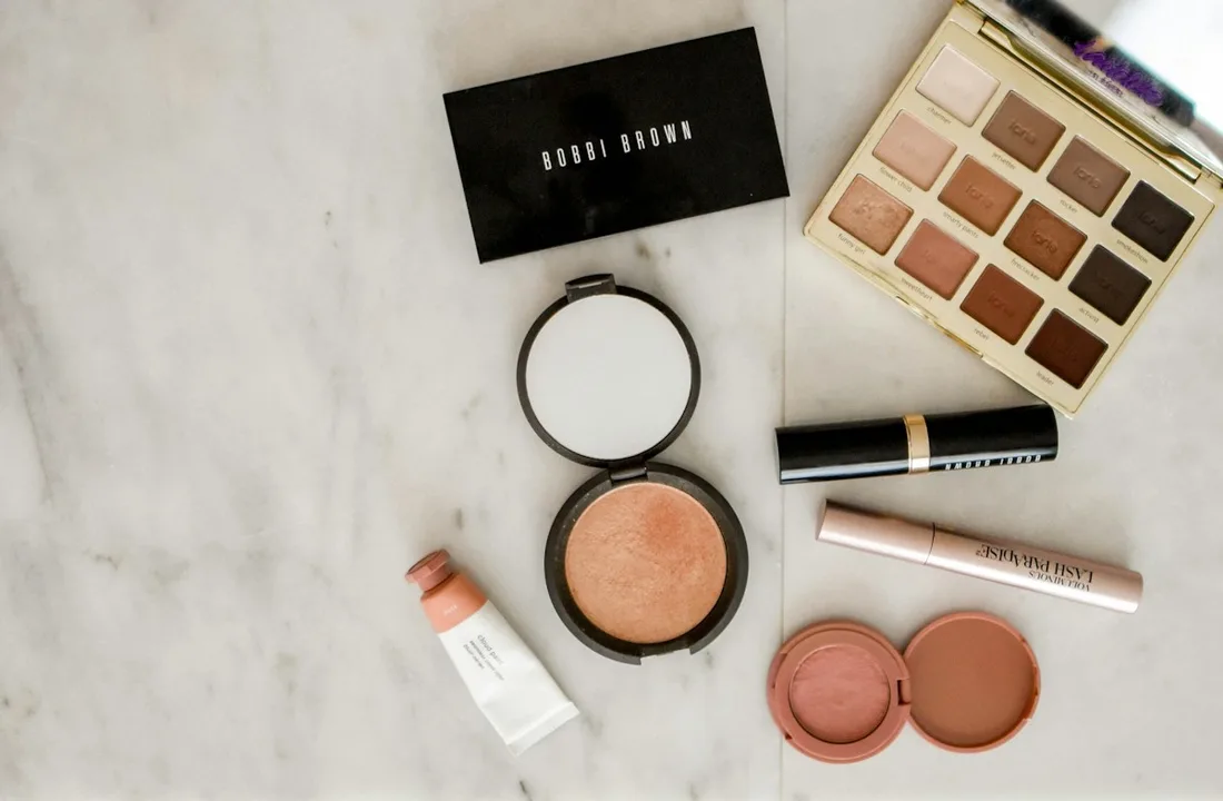 Compact cosmetics and makeup palettes displayed on marble