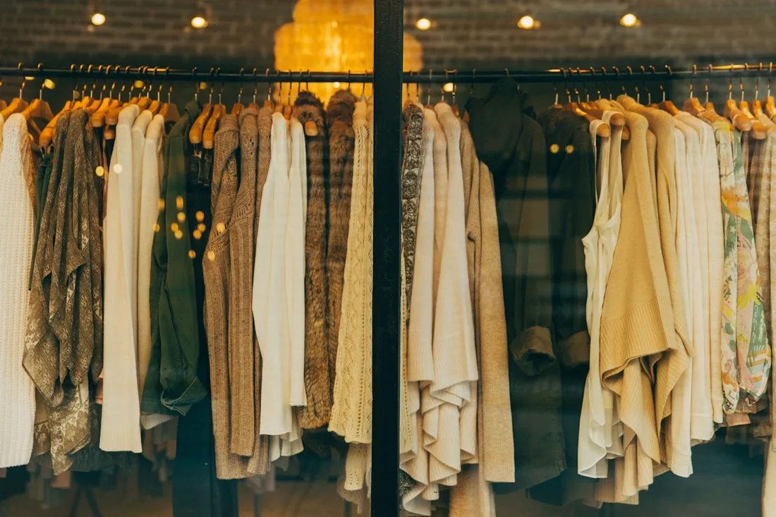 Garments displayed inside a warmly lit clothing store
