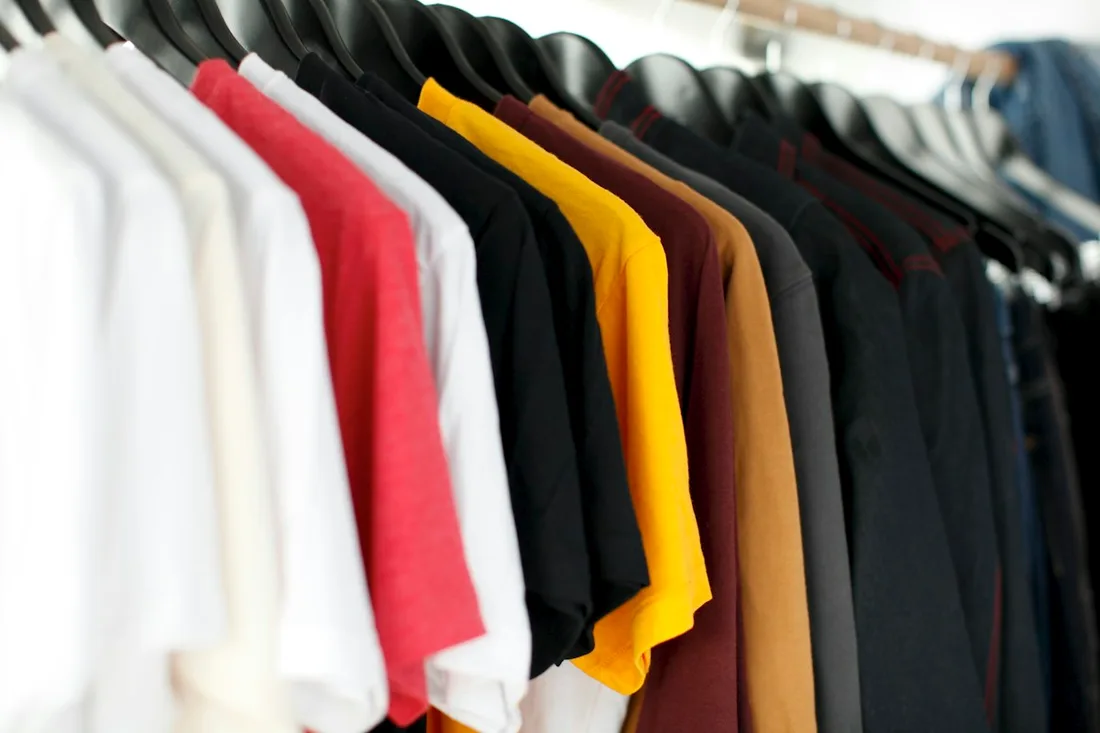 Brightly colored shirts grouped on hangers
