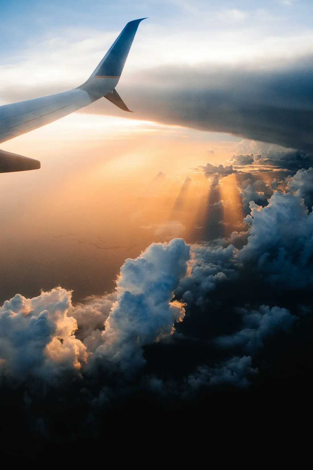 Airplane wing above a cloud layer on a daytime journey